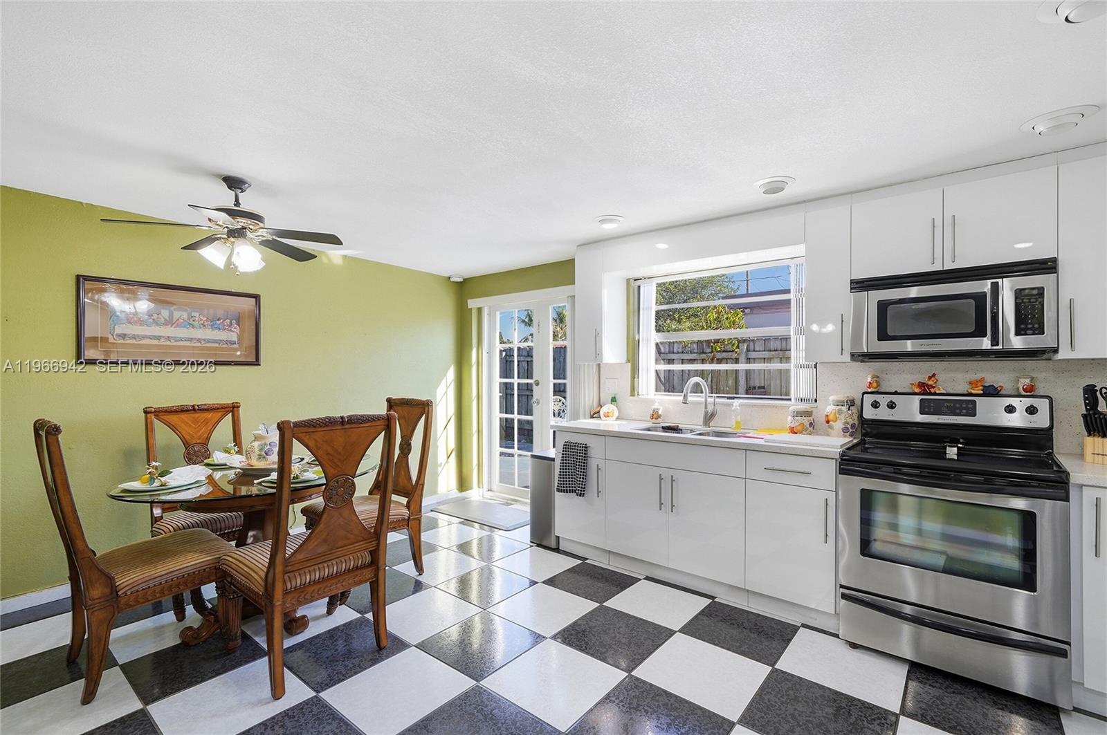 4791 West 3rd Avenue Hialeah, FL 33012 - Photo 19 of 30 a kitchen with a dining table chairs and stainless steel appliances