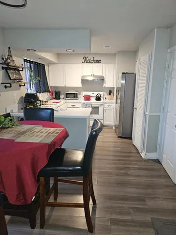 a kitchen with refrigerator and chairs