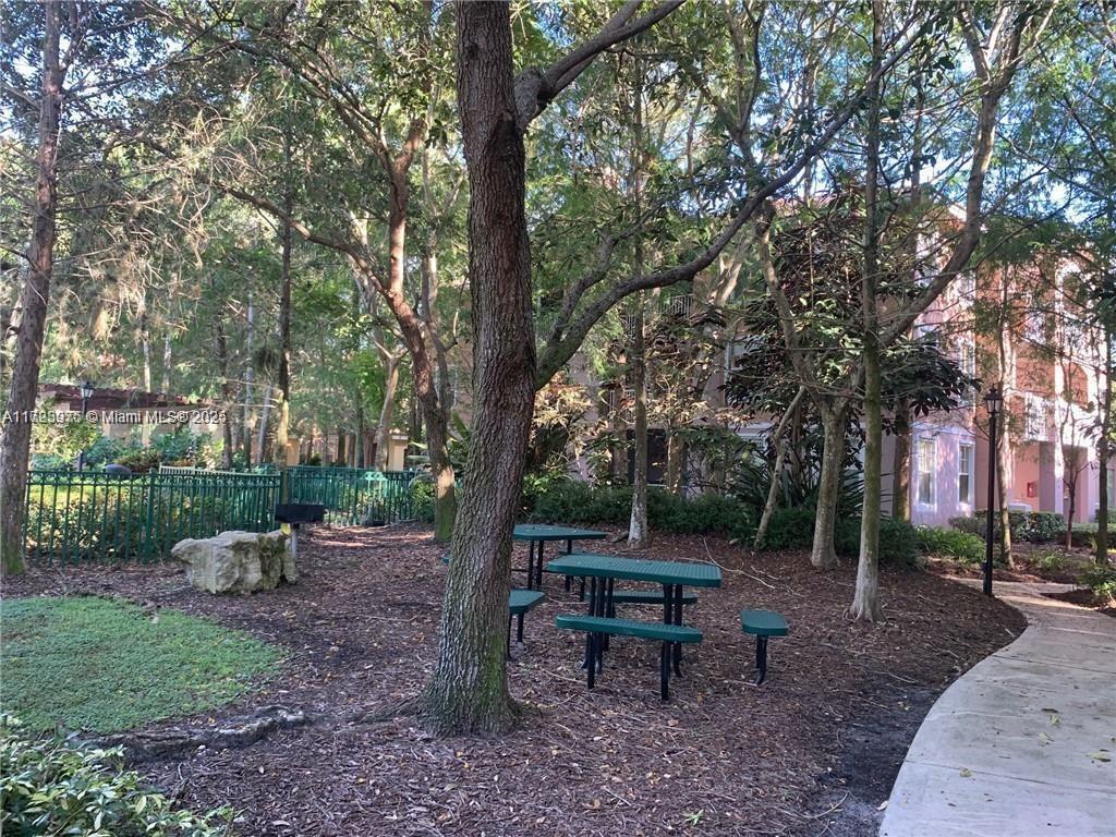 6776 West Sample Road, Unit 6776 Coral Springs, FL 33067 - Photo 18 of 20 a view of a park with a bench and a tree