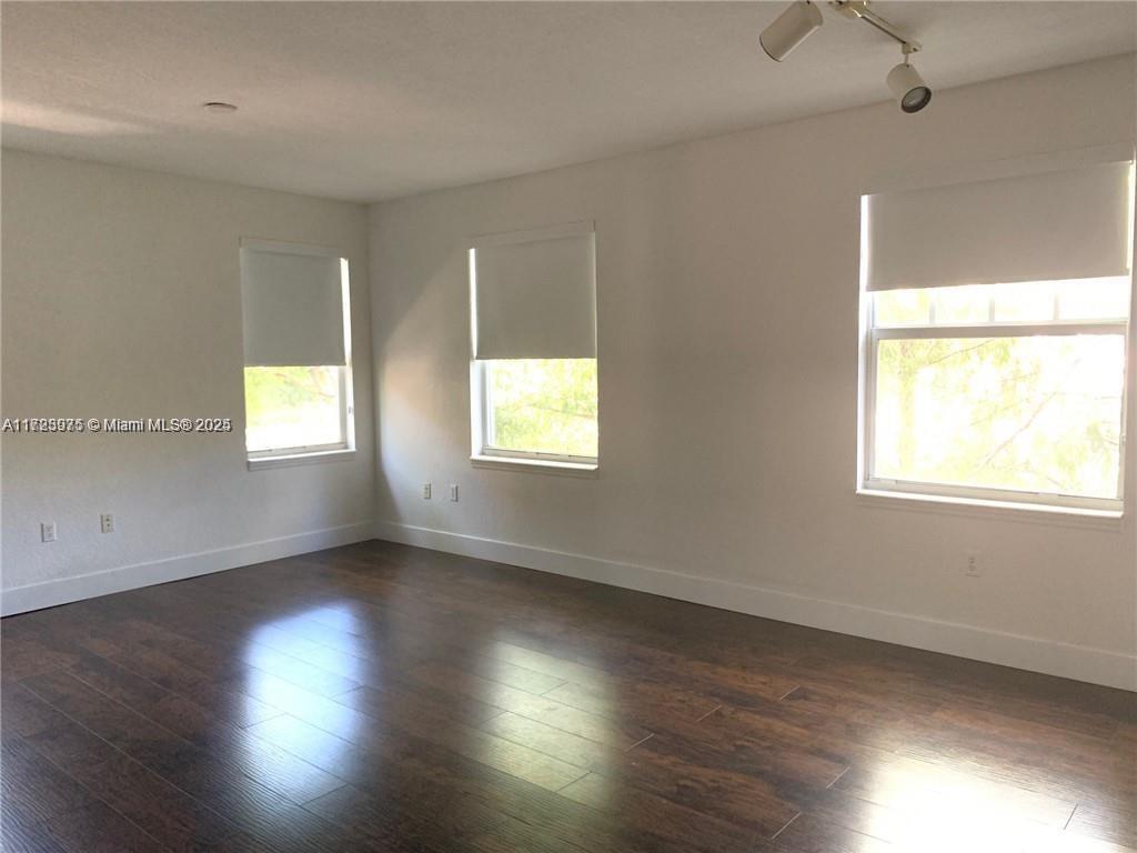 6776 West Sample Road, Unit 6776 Coral Springs, FL 33067 - Photo 2 of 20 an empty room with wooden floor and windows