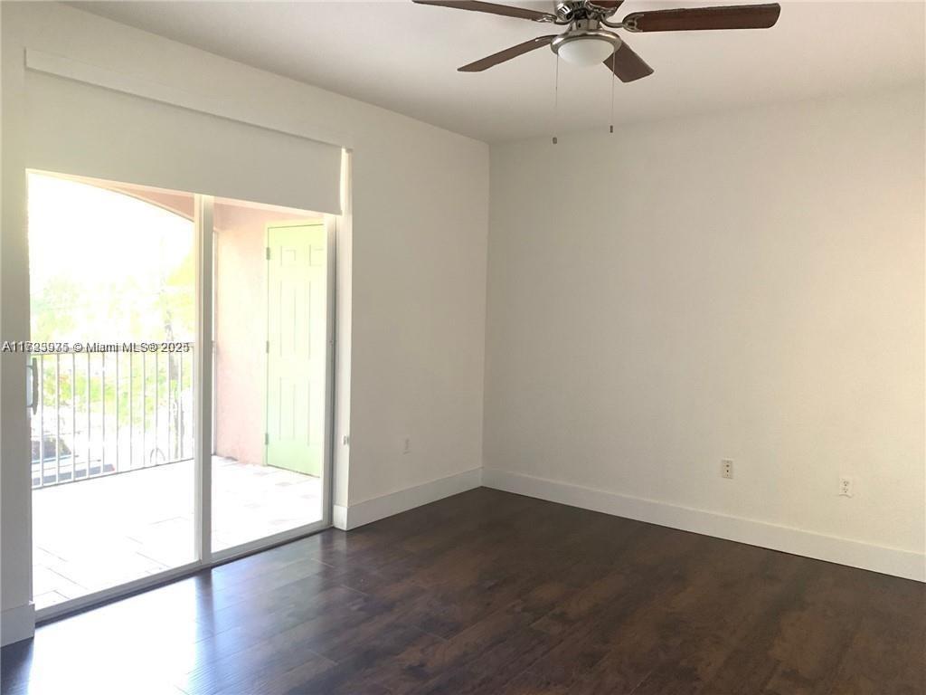 6776 West Sample Road, Unit 6776 Coral Springs, FL 33067 - Photo 6 of 20 an empty room with wooden floor fan and windows