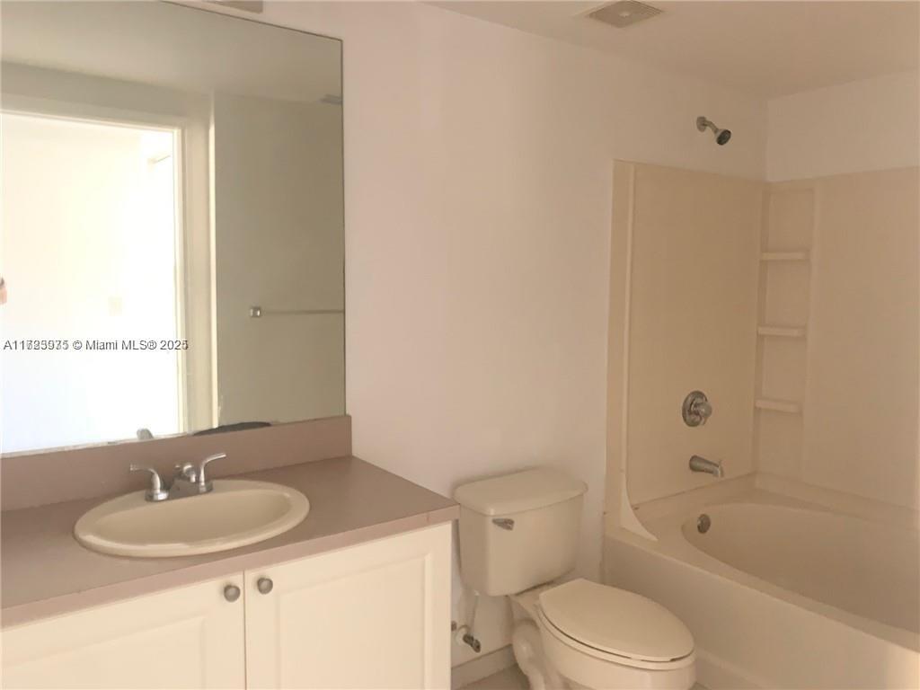 6776 West Sample Road, Unit 6776 Coral Springs, FL 33067 - Photo 7 of 20 a bathroom with a granite countertop sink toilet a mirror and shower