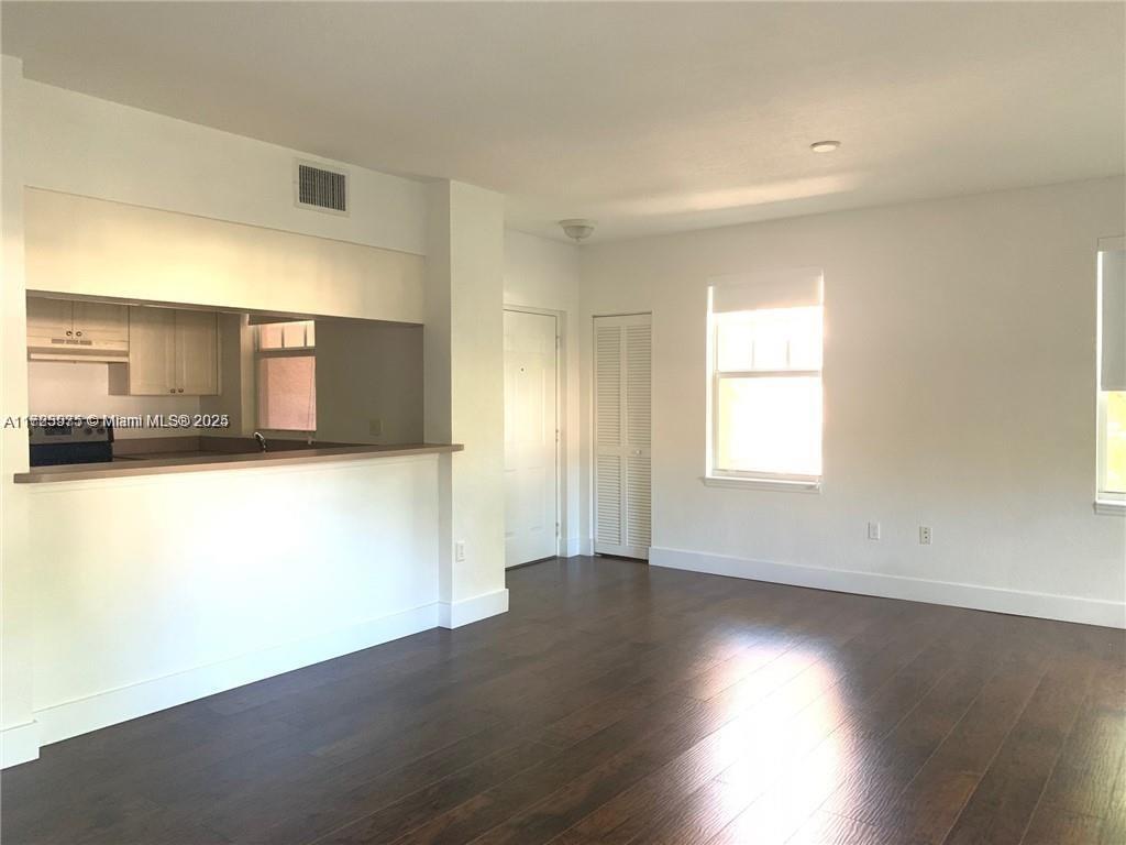 6776 West Sample Road, Unit 6776 Coral Springs, FL 33067 - Photo 10 of 20 an empty room with wooden floor and windows