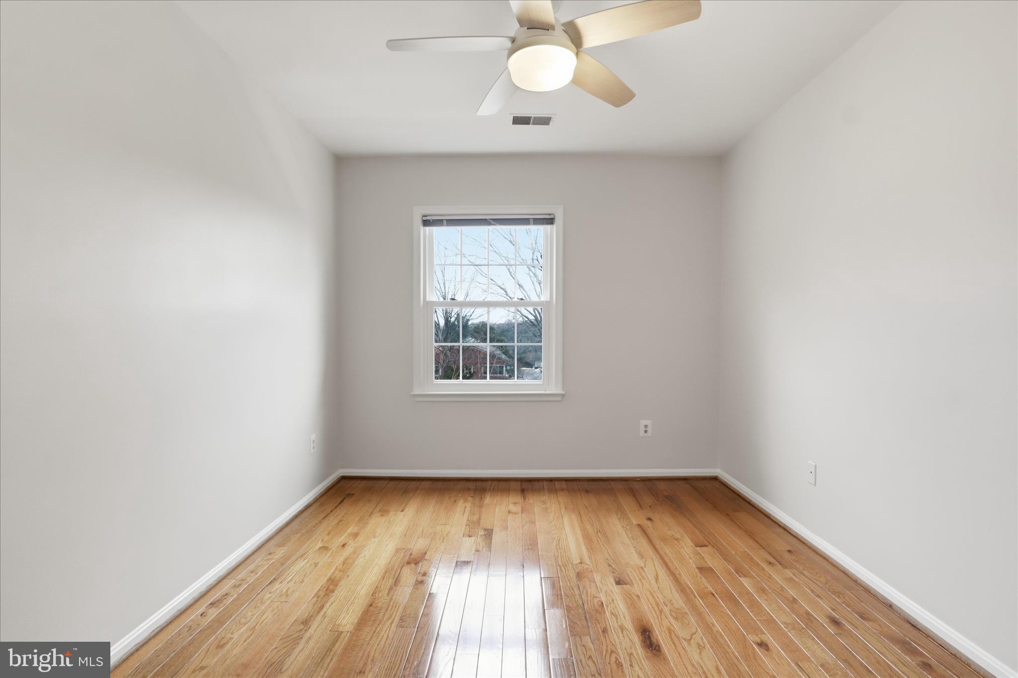 4851 Sangamore Road, Unit 25 Bethesda, MD 20816 - Photo 23 of 41 an empty room with wooden floor and windows