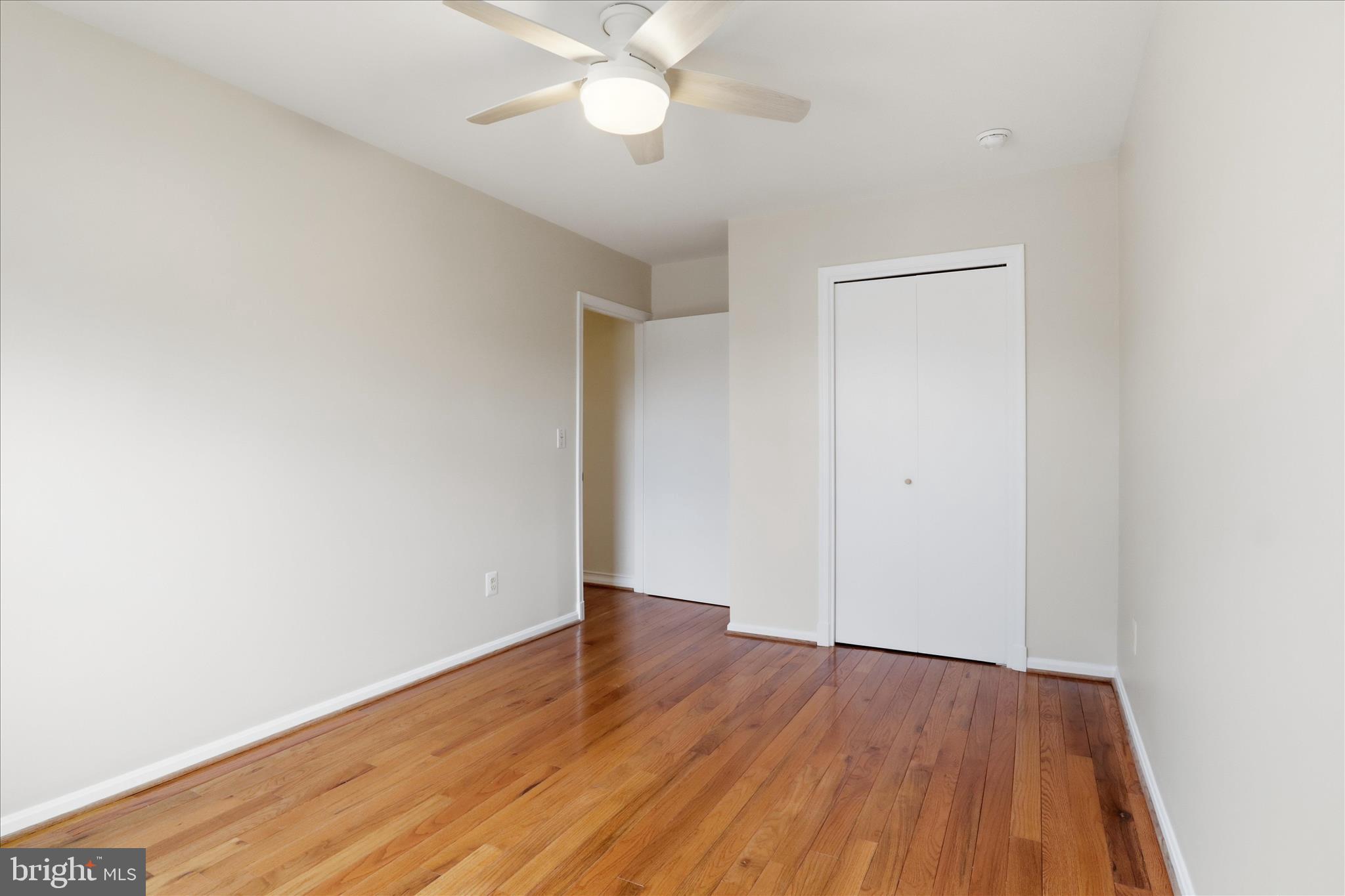 4851 Sangamore Road, Unit 25 Bethesda, MD 20816 - Photo 28 of 41 an empty room with wooden floor and windows