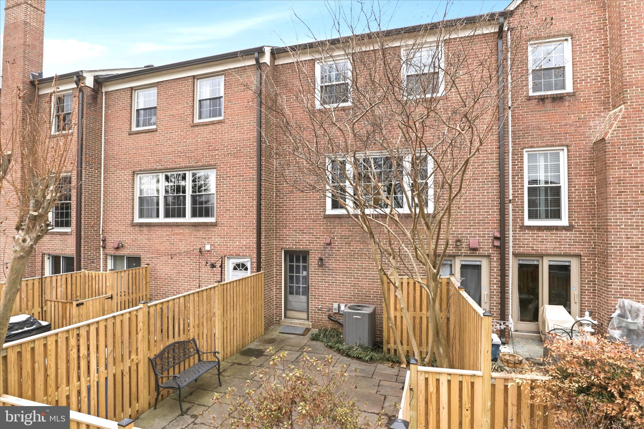 4851 Sangamore Road, Unit 25 Bethesda, MD 20816 - Photo 30 of 41 a porch with a bench next to a yard