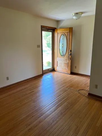 a view of a room with wooden floor and a window