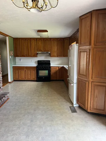 a view of an empty room with a fireplace and a window