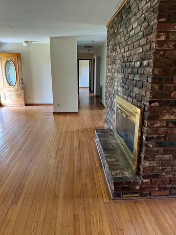 a view of an empty room with furniture and a window
