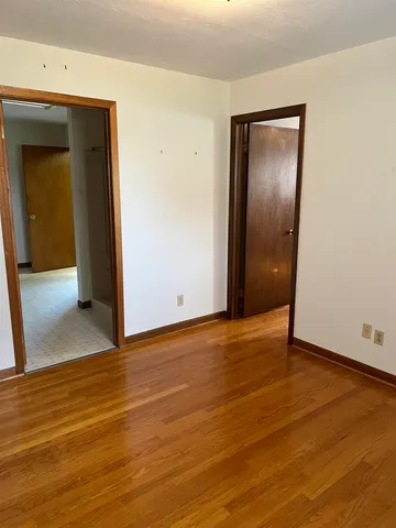 an empty room with wooden floor and door