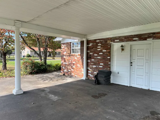 a view of a porch with furniture and a yard