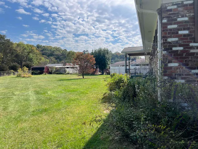 a view of a backyard with table and chairs with couches and plants