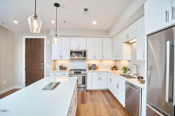 a kitchen with stainless steel appliances a stove a sink a refrigerator and cabinets