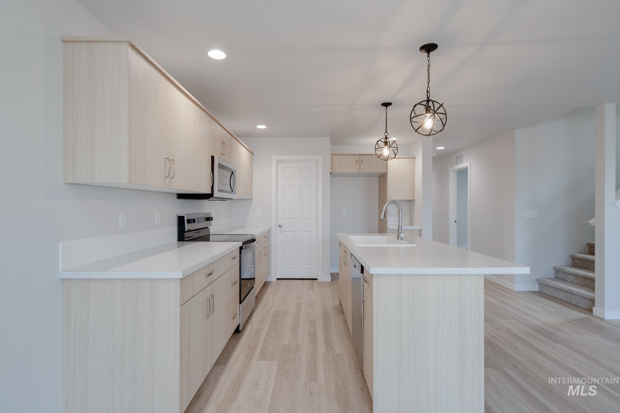 3089 South Maple Rnch Way Nampa, ID 83686 - Photo 7 of 22 Kitchen featuring stainless steel appliances, light countertops, light brown cabinetry, and recessed lighting