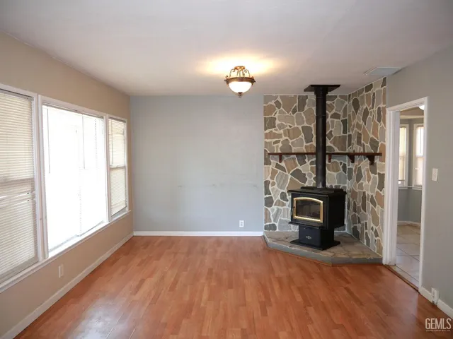a view of empty room with a fireplace and wooden floor