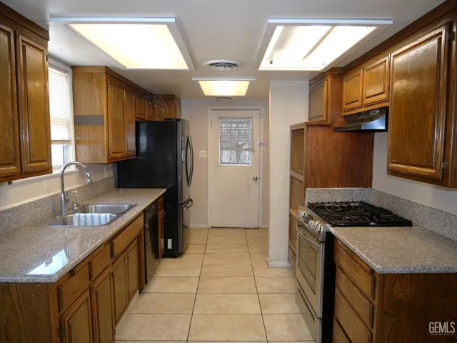 a kitchen with stainless steel appliances granite countertop a sink stove and refrigerator