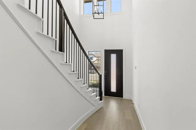 a view of staircase with railing and white walls