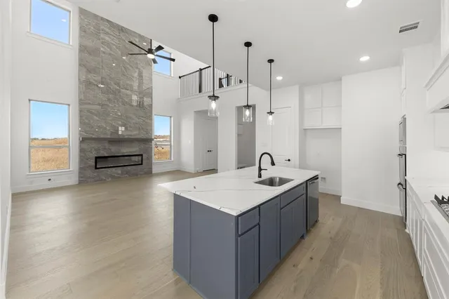 a large kitchen with a sink a refrigerator and a stove