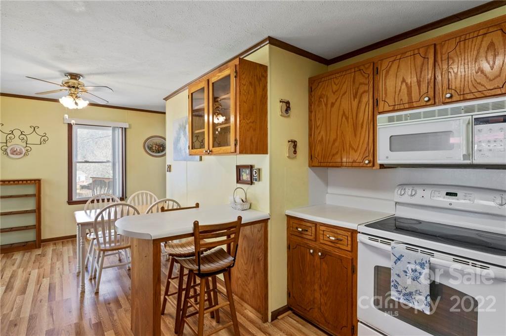 677 Monteith Branch Road Sylva, NC 28779 - Photo 8 of 48 a kitchen with stainless steel appliances granite countertop a stove a sink dishwasher and cabinets with wooden floor