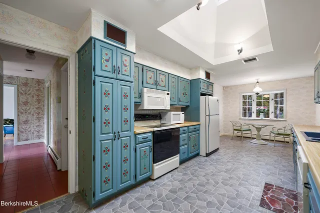 a kitchen with stainless steel appliances kitchen island granite countertop a refrigerator and a stove