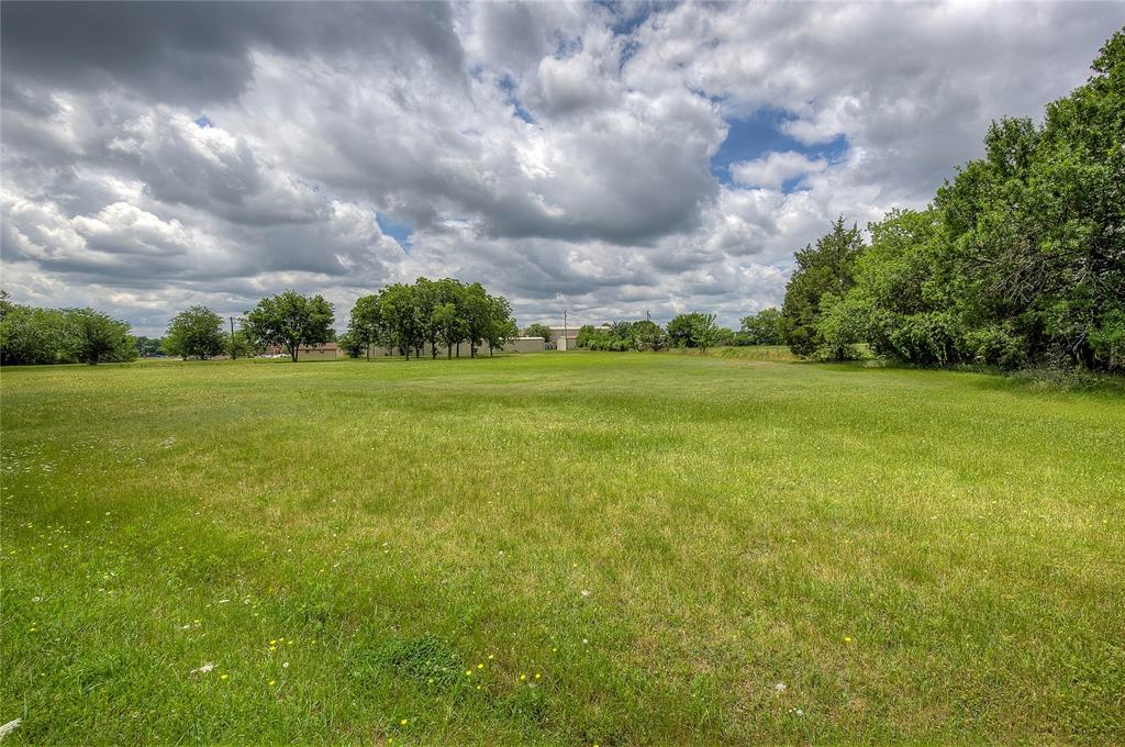221 Maple Street Commerce, TX 75428 - Photo 11 of 19 a view of a big yard with lawn chairs and a fountain
