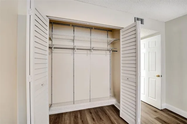a view of hallway with a large window and wooden floor