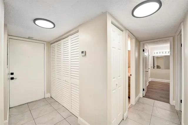 a view of a hallway with wooden floor and a bathroom