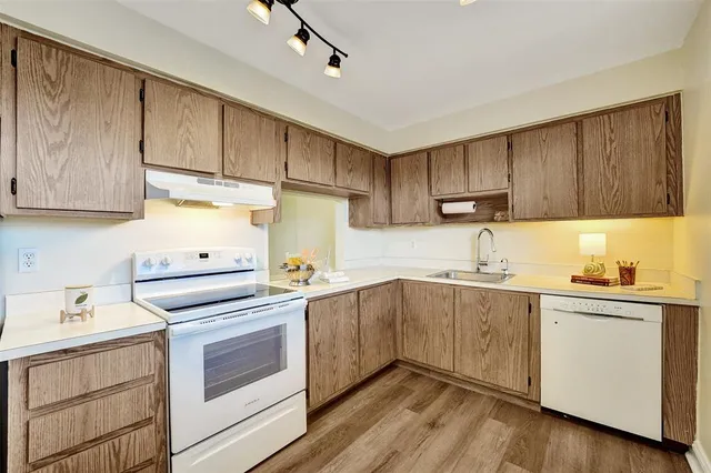 a kitchen with cabinets appliances a sink and a counter space