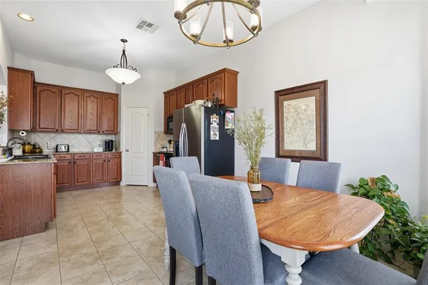 a living room with stainless steel appliances kitchen island granite countertop furniture and a chandelier