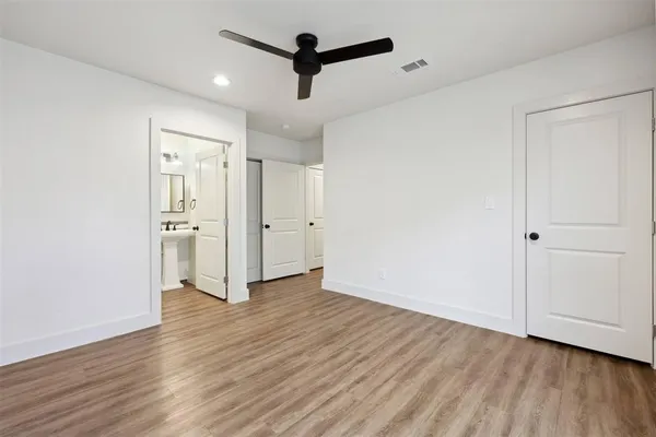 an empty room with wooden floor and ceiling fan