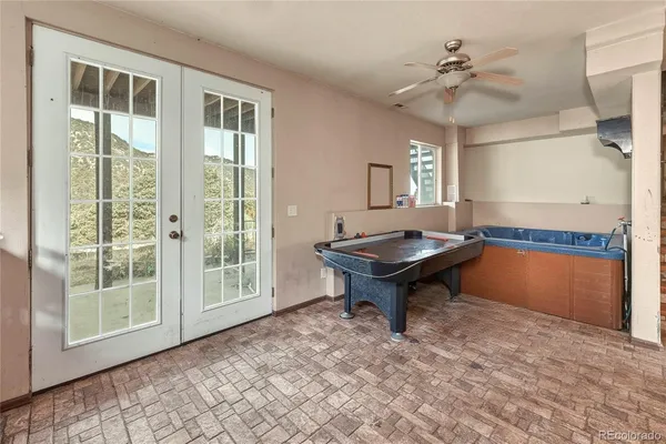 a living room with pool table and a window