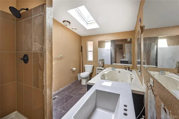 a bathroom with a tub sink shower and mirror