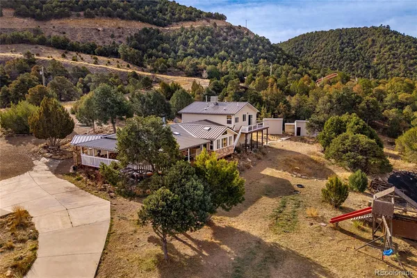 a aerial view of a house with a yard and mountain view in back