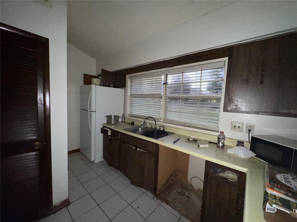 11001 Southeast Sunset Harbor Road, Unit D21 Summerfield, FL 34491 - Photo 6 of 15 a kitchen with stainless steel appliances granite countertop a sink stove and refrigerator