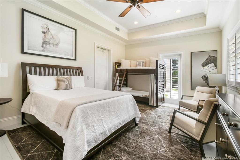 2541 Southwest Trailside Path Stuart, FL 34997 - Photo 59 of 100 a spacious bedroom with a bed a couch and a chandelier