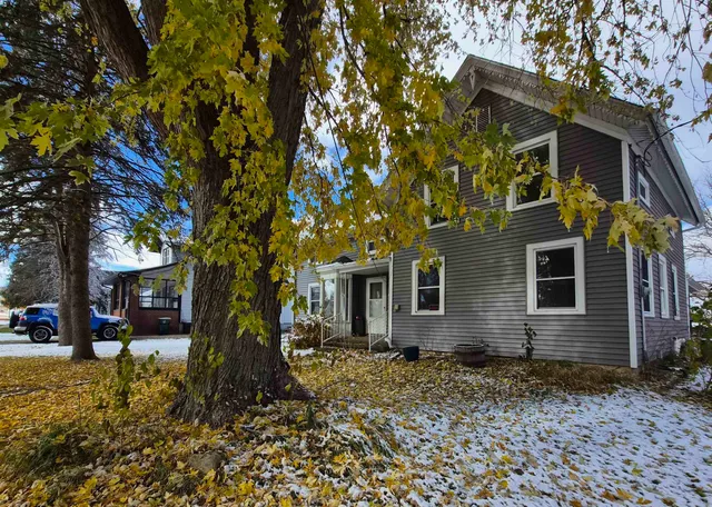 a view of a house with a tree in the yard
