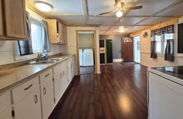a large kitchen with a lot of counter space and wooden floor