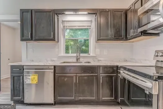 a kitchen with stainless steel appliances granite countertop a sink and a stove