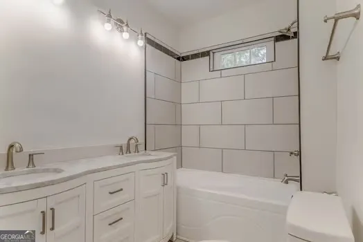 a bathroom with a granite countertop sink a toilet and shower