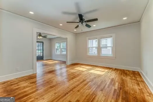 a view of an empty room and window and wooden floor