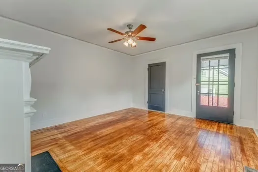 a view of an empty room with window and wooden floor