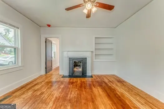 an empty room with a fireplace and wooden floor
