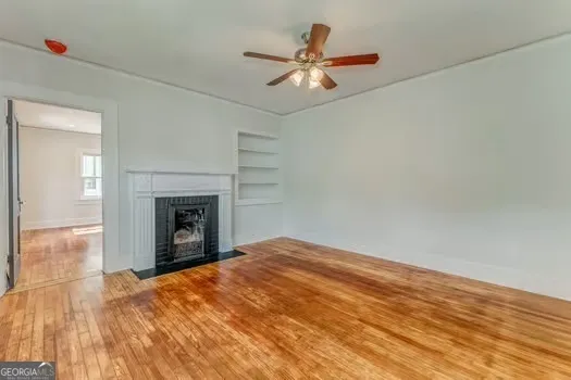 a view of empty room with fan and fireplace