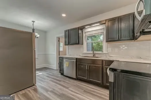 a kitchen with stainless steel appliances granite countertop a sink stove and refrigerator