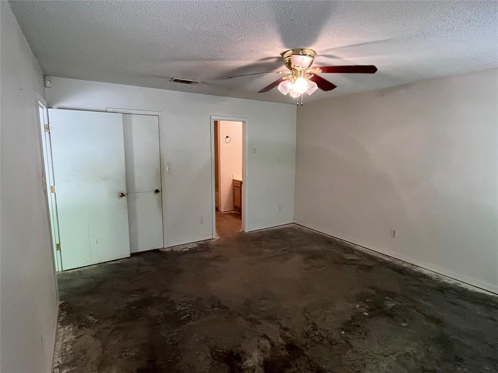 105 East Foggle Street Athens, TX 75751 - Photo 12 of 21 an empty room with a chandelier fan and closet area