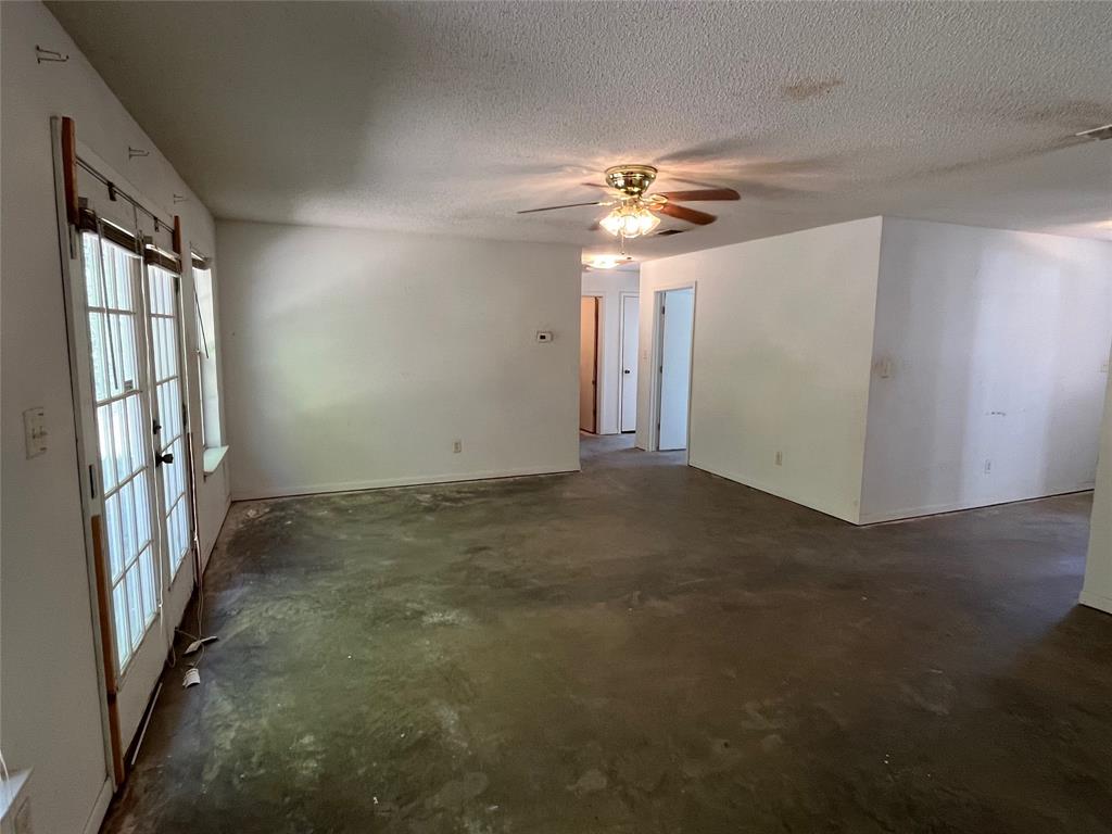105 East Foggle Street Athens, TX 75751 - Photo 15 of 21 an empty room with windows and chandelier fan