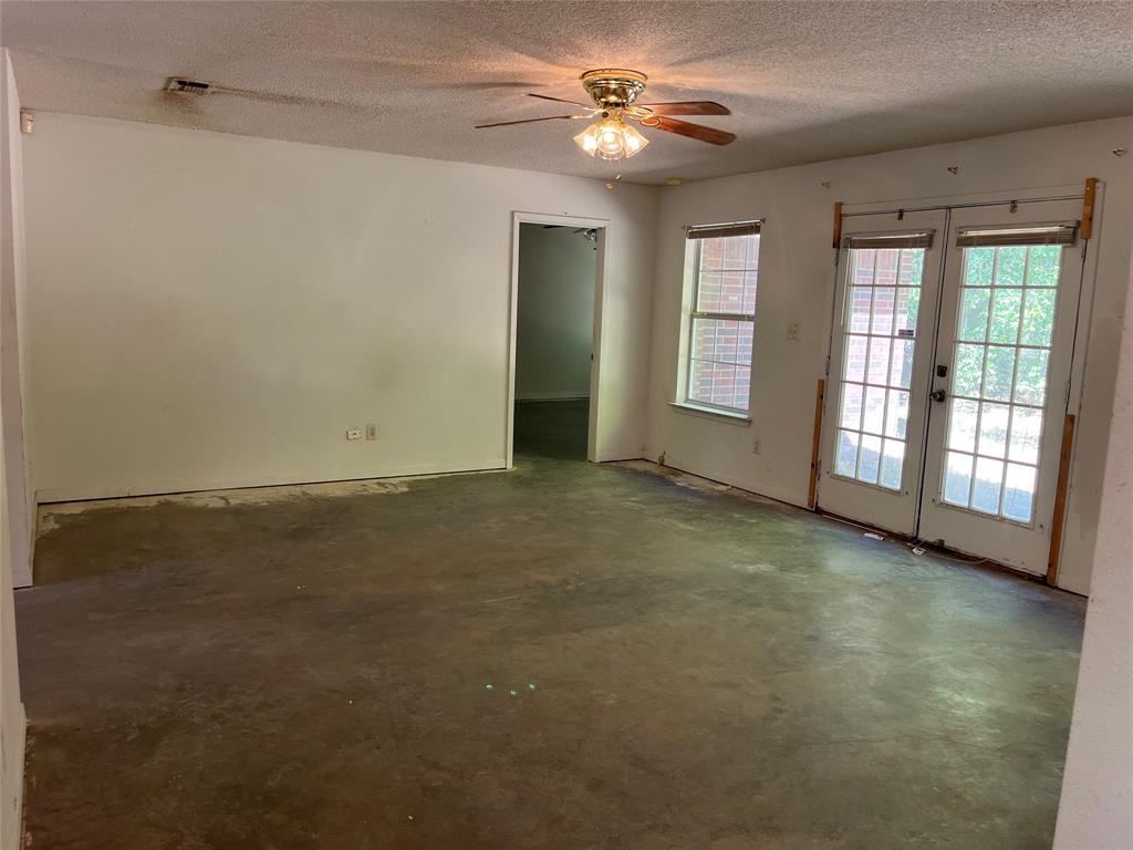 105 East Foggle Street Athens, TX 75751 - Photo 17 of 21 an empty room with windows and ceiling fan