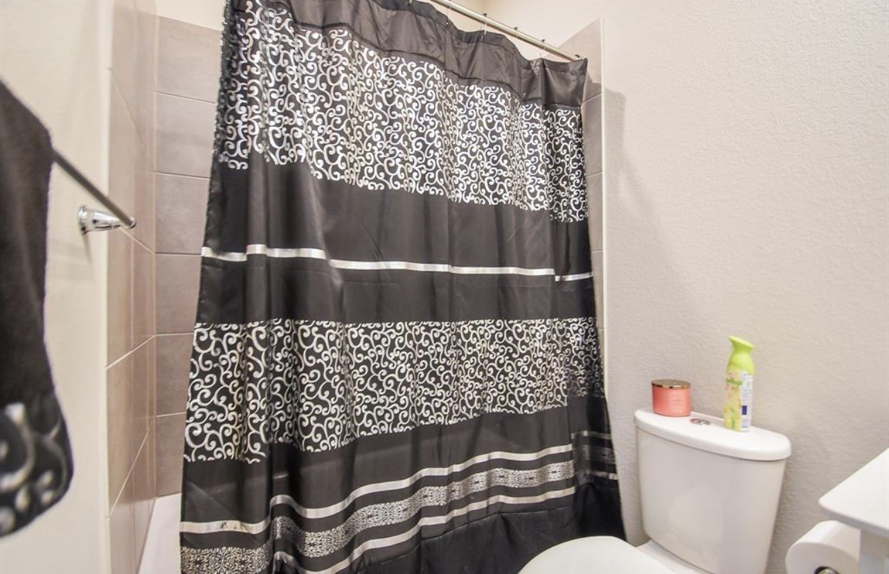 6927 Ventura Drive Rosharon, TX 77583 - Photo 16 of 24 a bathroom with a toilet and a shower curtain