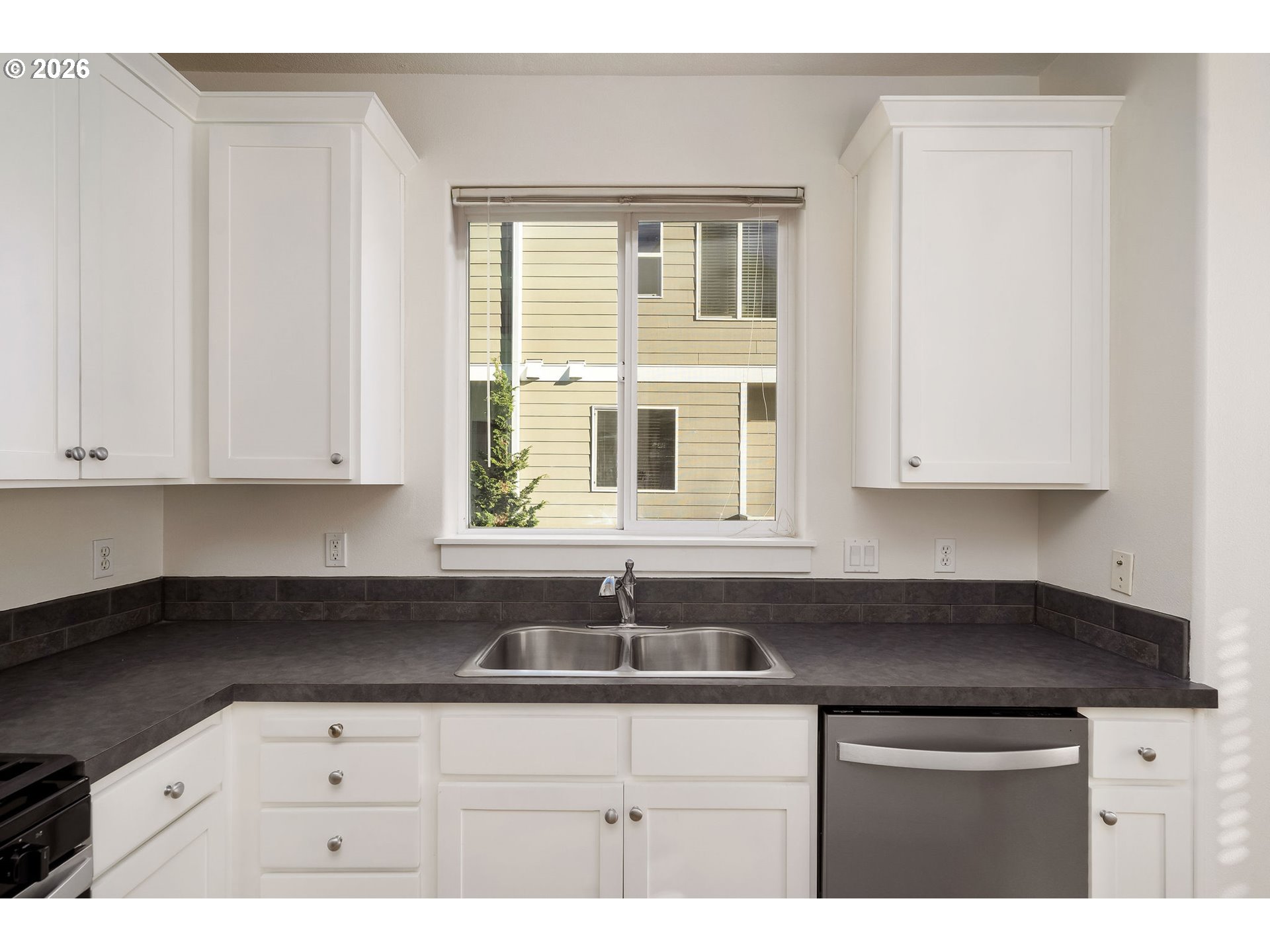1190 Southwest 162nd Avenue Beaverton, OR 97006 - Photo 18 of 36 a kitchen with granite countertop white cabinets sink and window