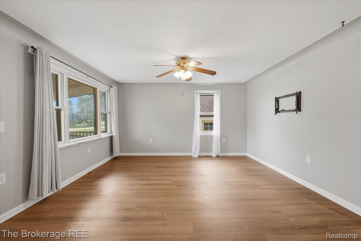 11973 East Brooks Road Lennon, MI 48449 - Photo 8 of 28 Wood-finish flooring, light gray walls, white trim, and a ceiling fan with integrated lighting